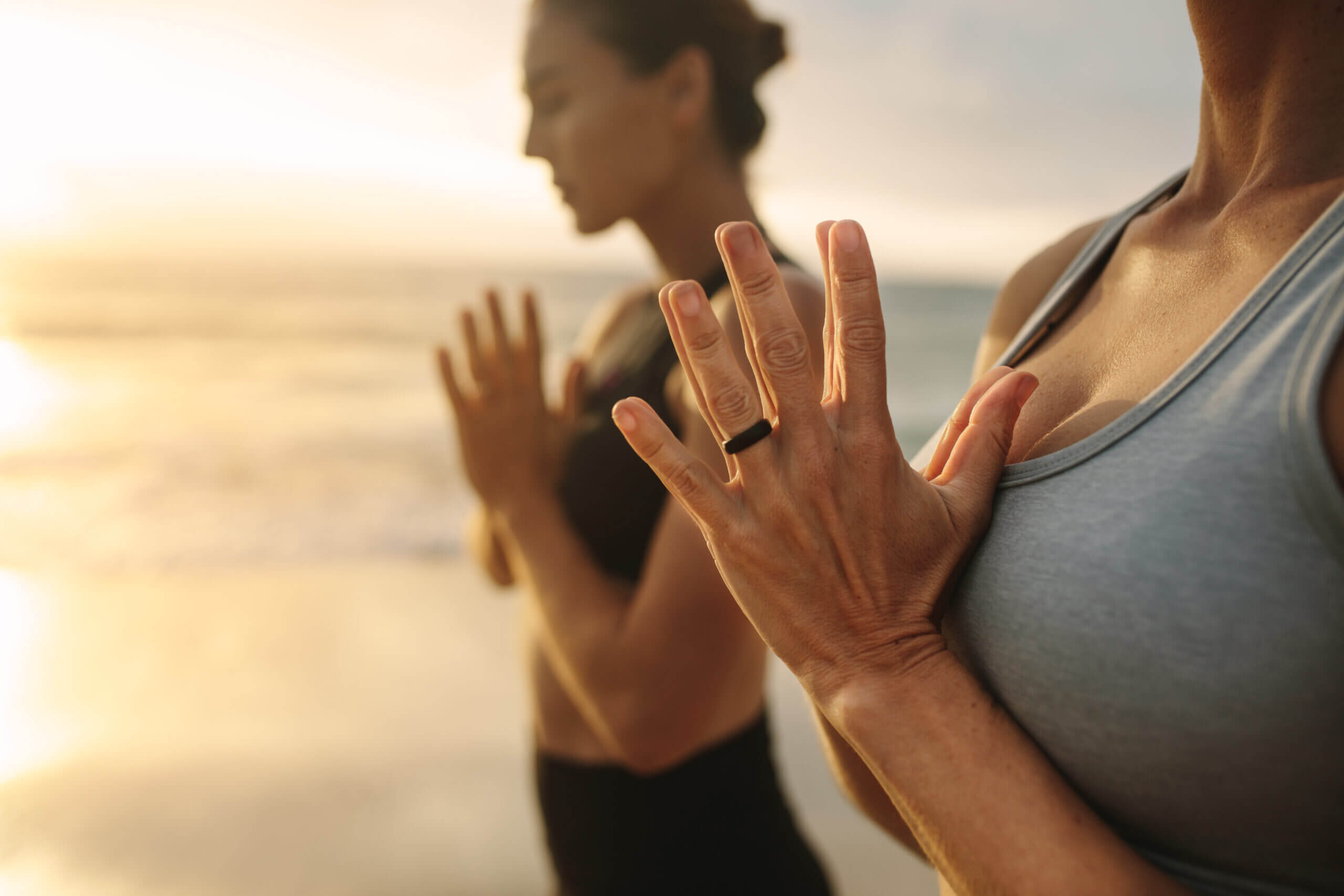 Two women practicing yoga on beach in Naples, Florida