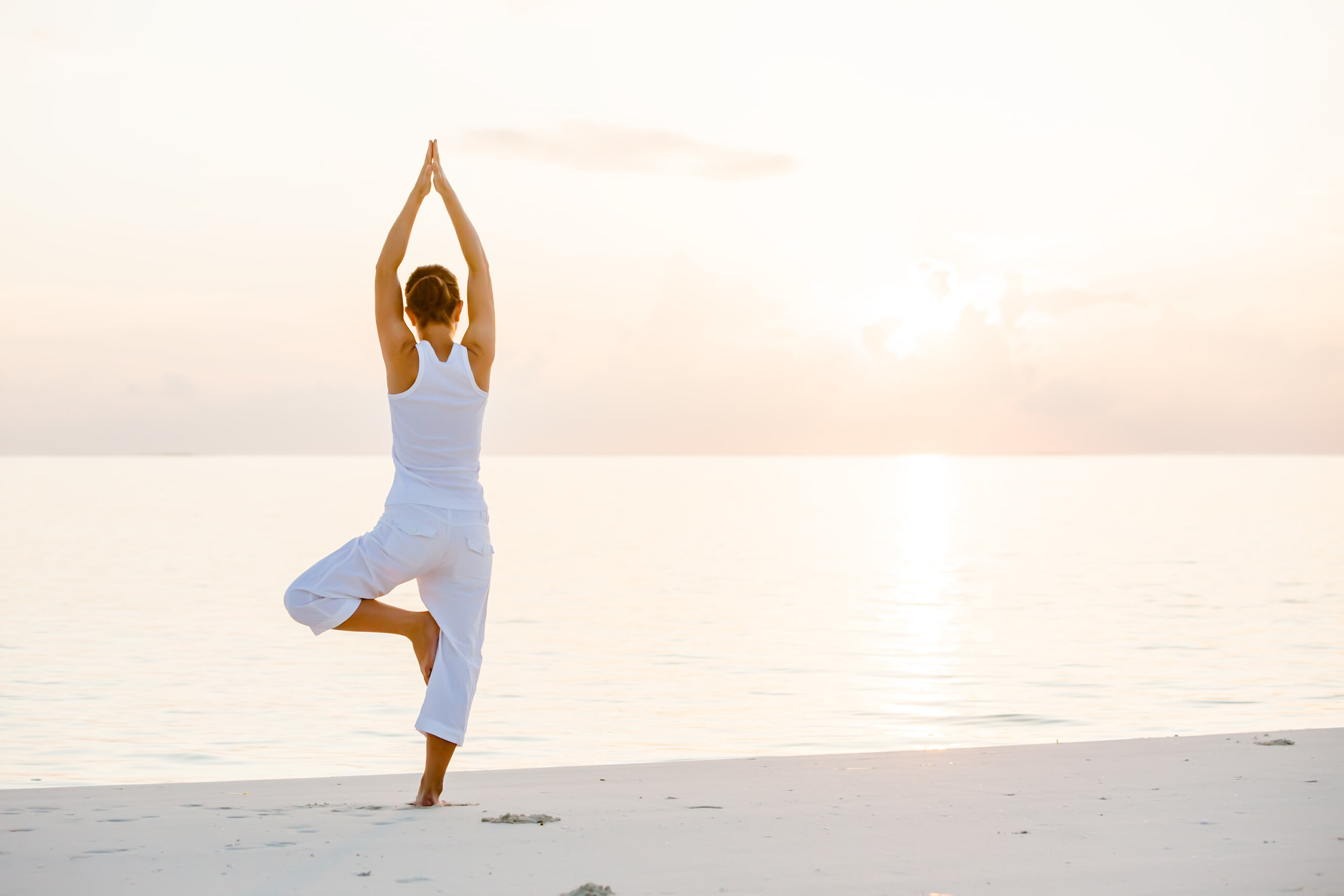 Woman doing yoga on a beach