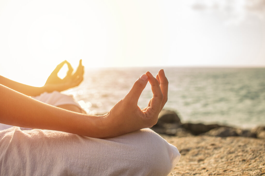 female in relaxed yoga pose on beach in Naples, FL